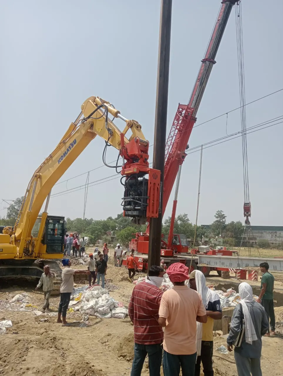 Pole driving on an open site, Uttar Pradesh, 2026, infrastructure work by M/S VKJJVBBNINFRA