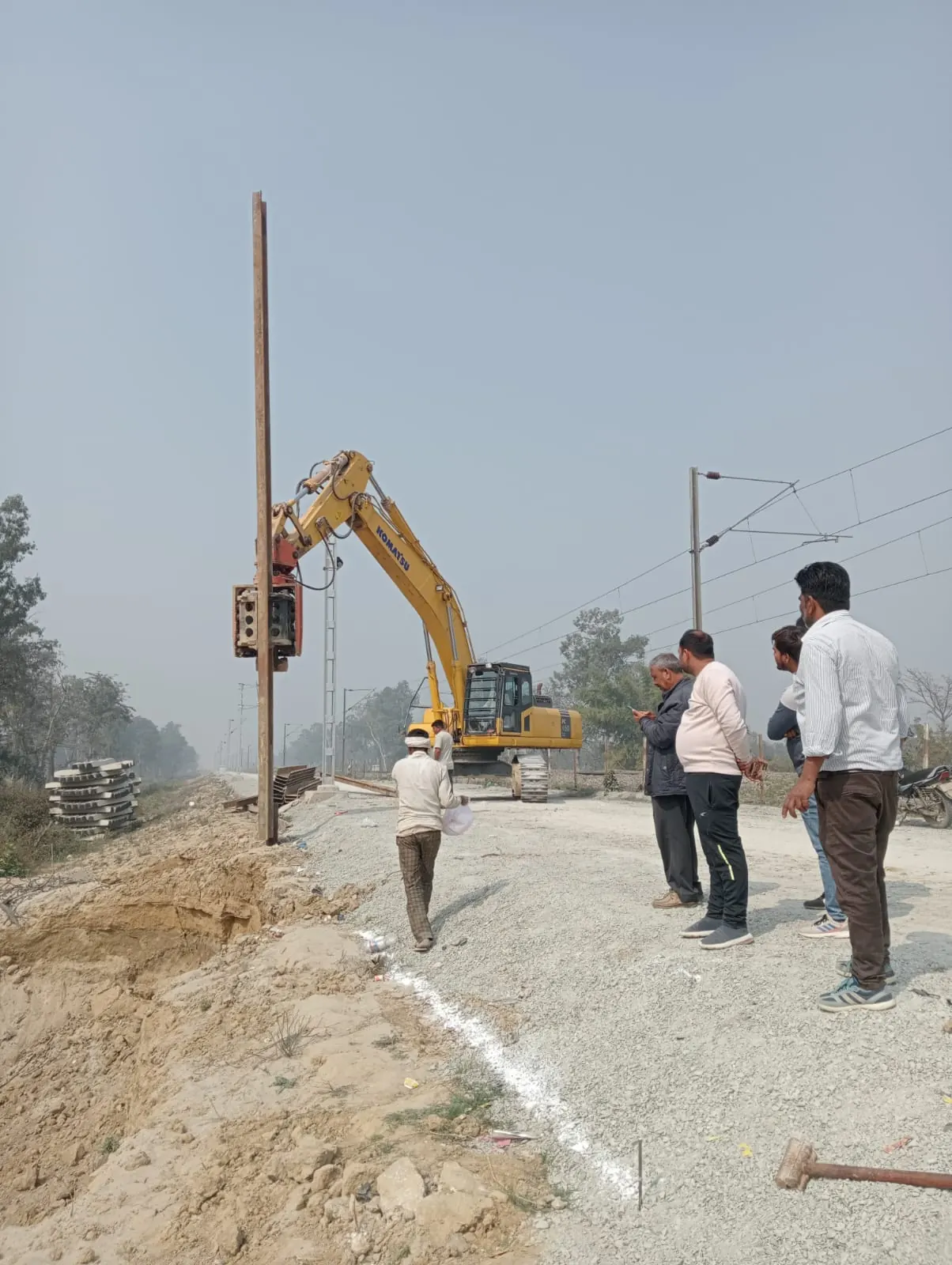 Pole driving on a village lane, Uttar Pradesh, 2026, infrastructure work by M/S VKJJVBBNINFRA